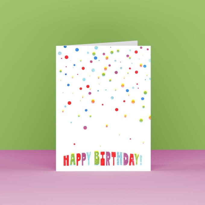 Front view of a happy birthday card with multi-colored falling dots that look like confetti
